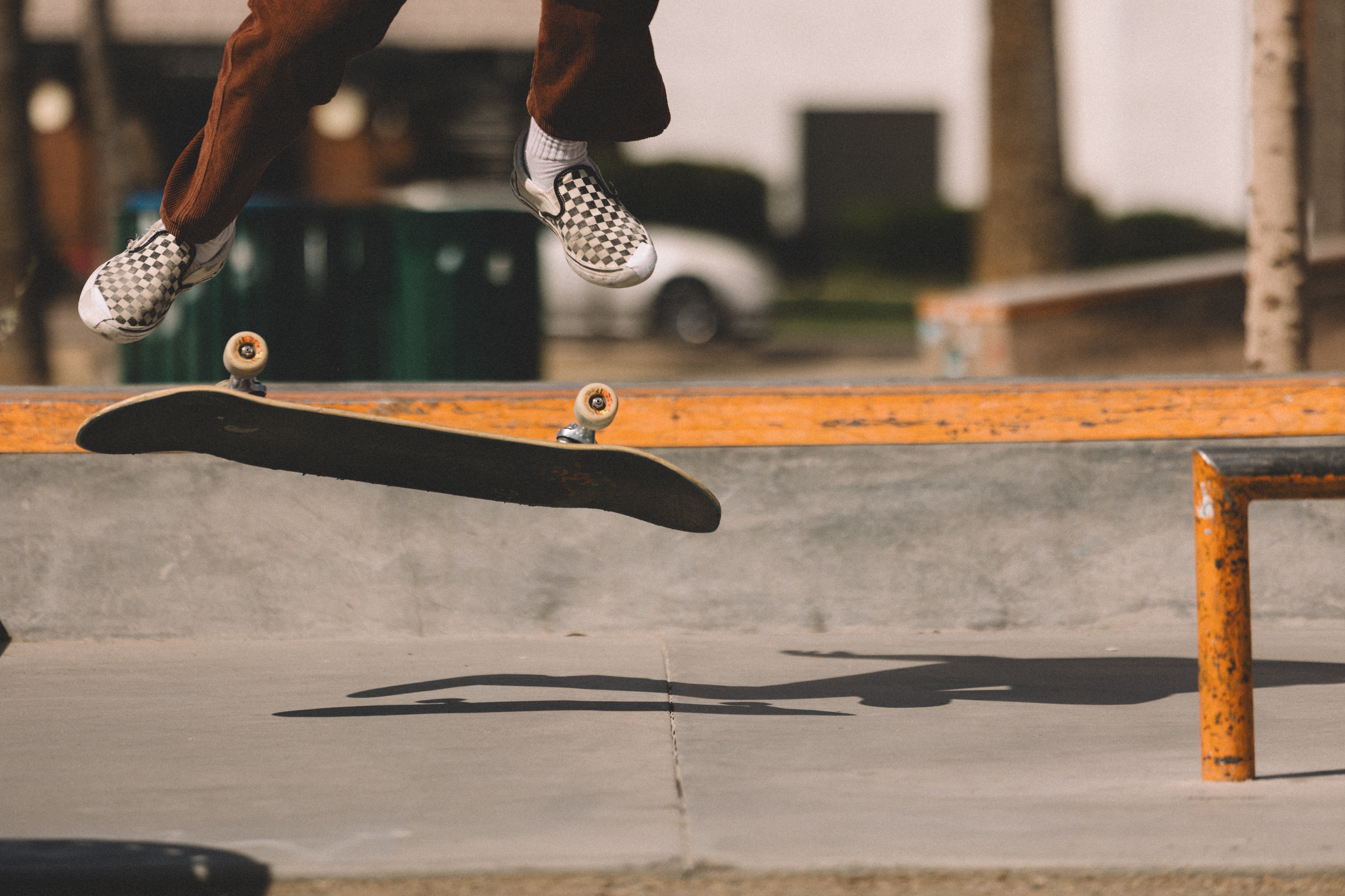 Skater kickflipping his board mid air with white TrickTape patches on both shoes